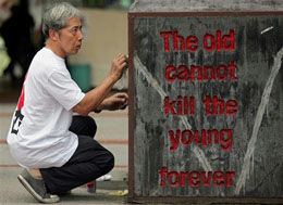 Човек, почистващ паметна плоча с надпис: „Старото не може да убива младото вечно”, поставена под изградения в чест на избитите на 4-ти юни 1989 г. от китайското правителство студенти монумент „Колона на срама”, намиращ се в Университета на Хонконг
