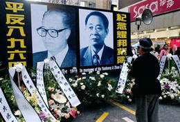 15 януари 2006 г. - гражданин на Хонконг, отдаващ почит към двамата китайски лидери, заплатили със своите лидерски позиции за симпатизиране на студентите – Жао Зиянг (вляво) по време на студентските протести през 1986 г., Ху Яобанг по време на студентските протести през 1989 г..