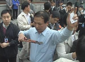 Чой Йонг-Хо от Младежкия либерален алианс показва на медиите областта в ляво на гърдите си, където е бил ранен с дълги клещи по време на атаките на китайските студенти.