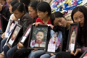 Майки с портрети на загиналите си деца от училище ‘Фушинг’ (Fuxing) в гр. Уфу, обл. Мианджу, провинция Сичуан