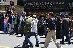 Нападнат практикуващ Фалун Гонг (в бялата риза) от про-комунистически поддръжник. 