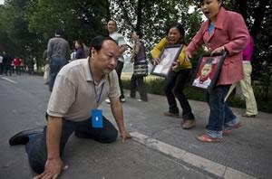 Джиянг Гуохуа (Jiang Guohua), партиен секретар на гр. Мианджу (Mianzhu) падна на колене, молейки родителите, загубили децата си при земетресението в Сичуан, да преустановят своя протестен марш към столицата на Сичуан, Ченгду (Chengdu).