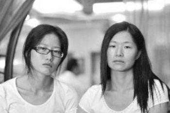 Джонг Руджиу (отляво) и сестра й, Джонг Ручуи, все още са в шок, след като са потърсили подслон в тоалетна на летище на 16 септември 2010 г. 