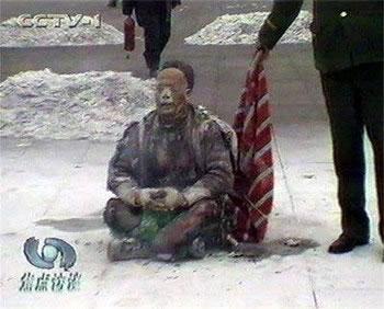 Един от многобройните кадри на инцидента със "самозапалването", показани по китайския канал CCTV, който представя фалшификацията. Полицай изчаква, докато седящият "самозапалващ се" извика в камерата фразата "Фалун Дафа е добро" и eдва след това хвърля върху него одеало.