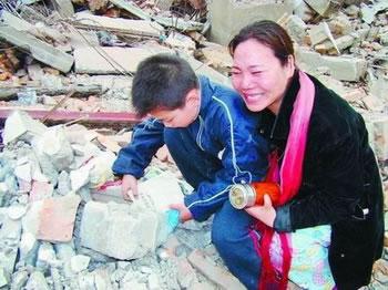 Го Ман плаче горчиво над руините да дома си, докато детето й си търси учебниците