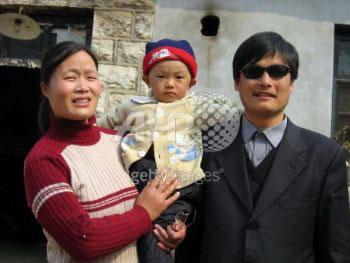 Снимка от 28 март 2005 г. на слепия активист Чен Гунгченг (отдясно) със съпругата му и сина му пред дома им в село Донгшигу, североизточната китайска провинция Шандонг.