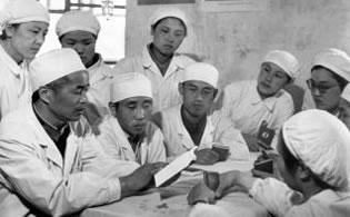 Група от млади медици, които изучават копия на "Малката червена книга" на Председателя Мао в болница в Пекин преди започване на трудовия ден по време на "Великата пролетарска културна революция"