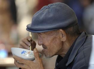 Възрастен човек обядва в Пекин, октомври 2011 г. 