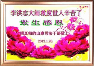 Картичката гласи: "Съдебните служители в провинция Шандонг, които научиха фактите за преследването на Фалун Гонг, честитят Новата Година на Мастър Ли!" Януари 2012. 