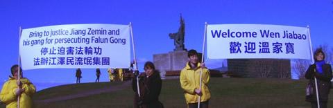 Фалун Гонг практикуващи държат банер в знак на протест срещу преследването и приветстват Уен Джябао с добре дошъл. 