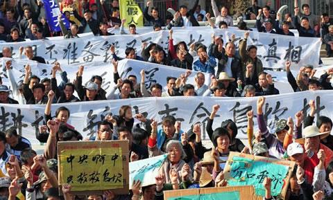 Жители държат банери по време на протест в Укан, провинция Гуангдонг, 19 декември 2011 г., изисквайки централните власти да предприемат действия за незаконното присвояване на земя и смъртта на задържан местен лидер. 