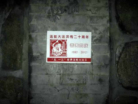 Постер, гласящ: "Честване на 20-та годишнина от представянето на Фалун Дафа на света", залепен на стена в Пекинския университет. 