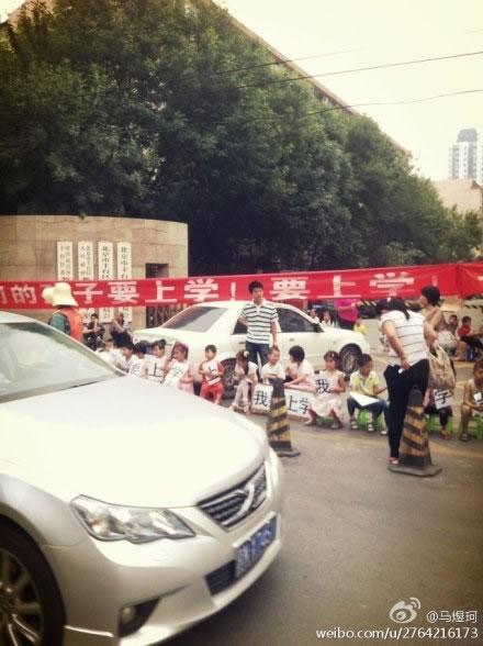 Група от малки деца протестира пред районната Комисия по образованието във Фенгтай, Пекин на 13 юни, седейки на столчета и викайки: "Искам да ходя на училище".