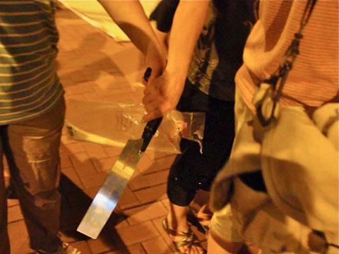 Съмишленик на асоциация „Hong Kong Youth Care“ държи голям нож по време на неотдавнашен инцидент, когато групата се опита да заплаши практикуващи Фалун Гонг.