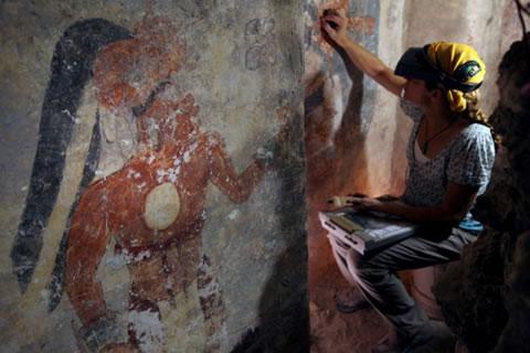 Консерваторът Анджелин Бас почиства и стабилизира повърхността на стена в къща на маите, датираща от 9-ти в. пр. Хр. Фигурата на мъж, който може да е бил книжникът на града, се вижда на стената вляво от нея.