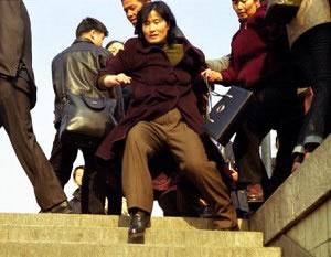 Китайски цивилни полицаи блъскат жена към подлеза на пл. Тянанмън на 24 януари 2002 г.